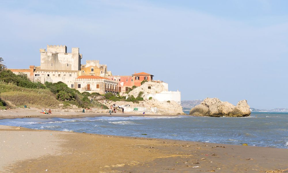 Il bellissimo castello di Falconara in Sicilia visto dalla spiaggia di sabbia. Era una soleggiata giornata estiva in questo bel posto nascosto situato vicino a Butera, Caltanissetta