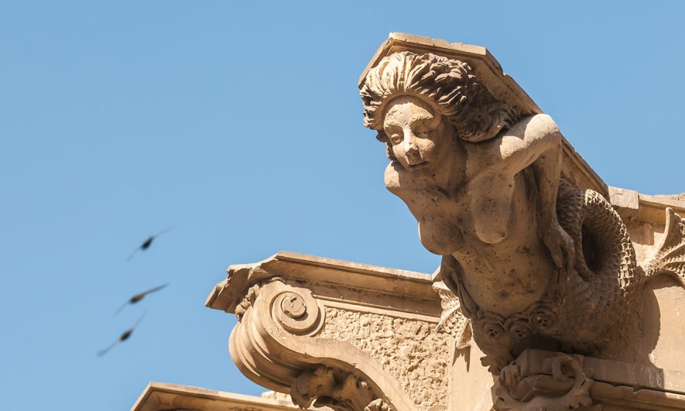 Scultura ornamentale di una sirena sul tetto di un palazzo barocco a Lentini, in Sicilia
